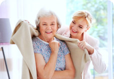 caregiver putting a blanket into an elder woman