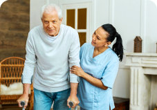 caregiver assisting an elder man to walk
