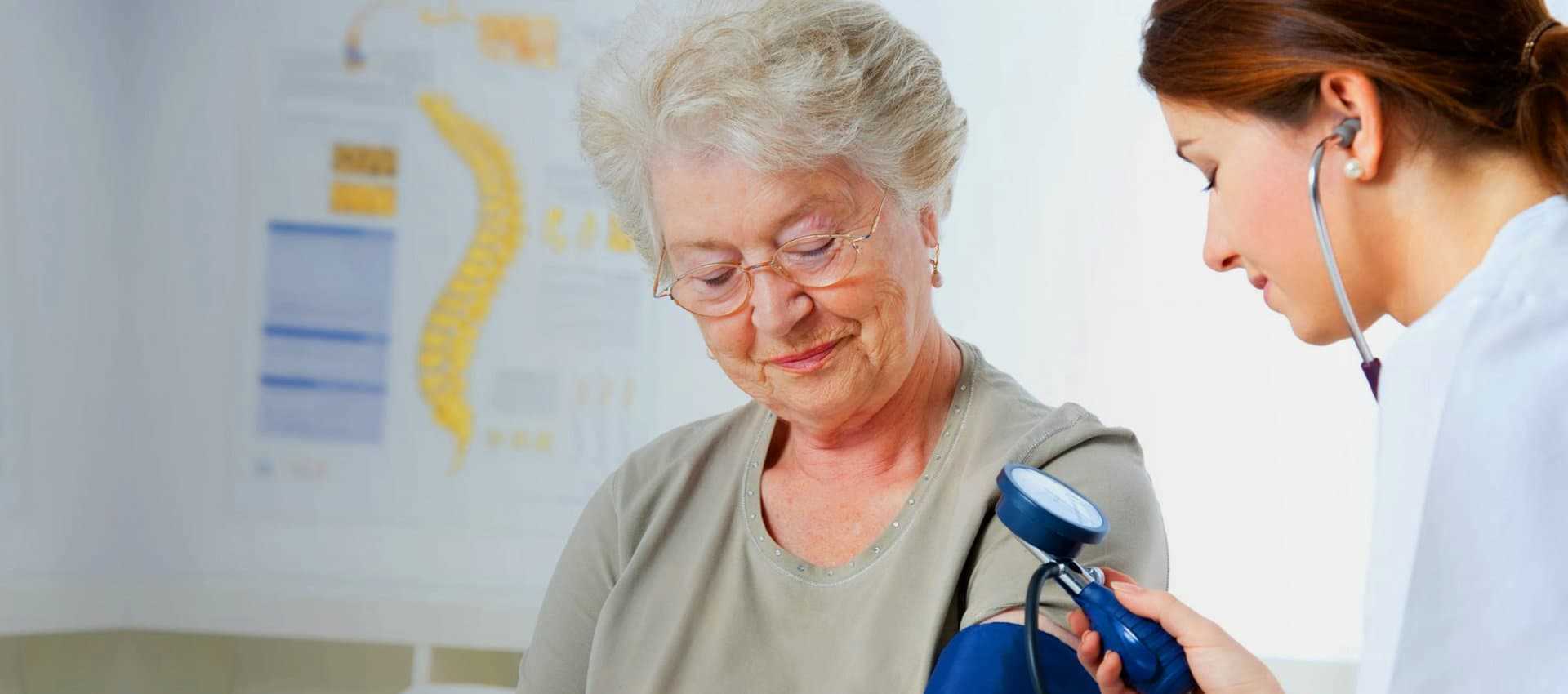 nurse measuring an elder woman blood pressure