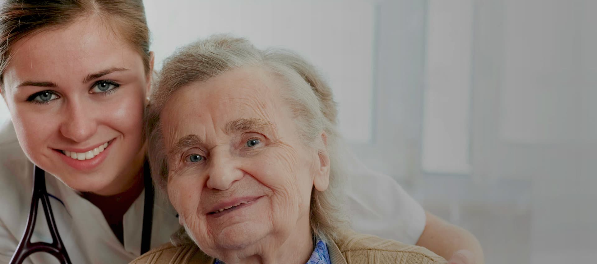 nurse hugging an elder woman